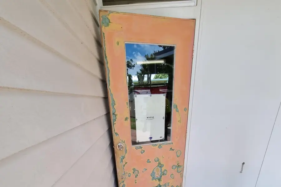 A freshly painted white interior corner with a weathered door frame